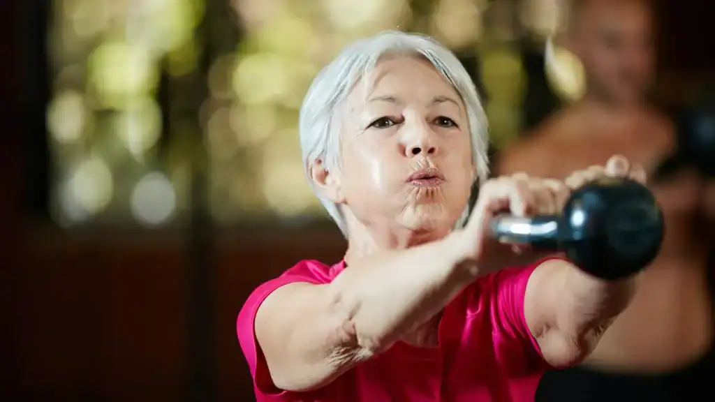 Older woman doing weight training Hassocks to help her strength and longevity 